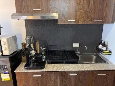 a kitchen counter with a sink and a stove at Destiny Hotel - 1601 in Manila