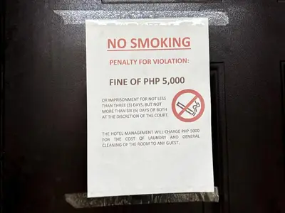 a no smoking sign is posted on a wall at Destiny Hotel - 1601 in Manila
