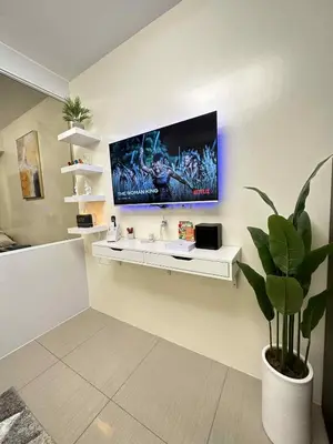 a bathroom with a sink and a tv on the wall at Cg's Staycations in Manila