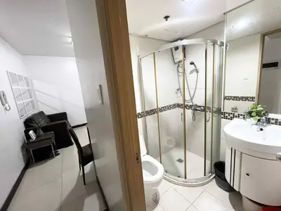 a bathroom with a shower and a toilet and a sink at Solemare parksuites with balcony tower C in Manila