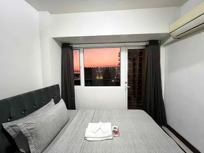 a bedroom with a bed and a window with a view at Solemare parksuites with balcony tower C in Manila