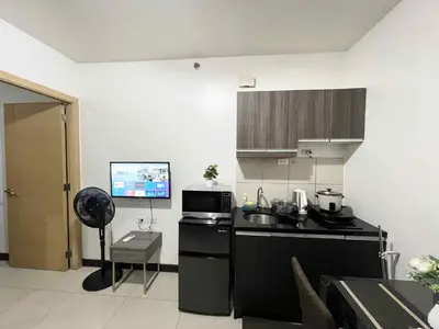 a kitchen with a sink and a microwave at Solemare parksuites with balcony tower C in Manila