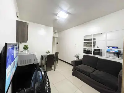 a living room with a couch and a dining room at Solemare parksuites with balcony tower C in Manila