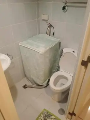 a small bathroom with a toilet and a sink at Pasay Staycation across MOA in Manila