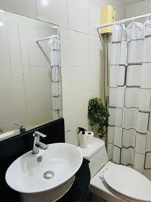 a bathroom with a sink and a toilet and a mirror at Stamford Studio Condo in McKinley Hill, BGC Taguig in Manila