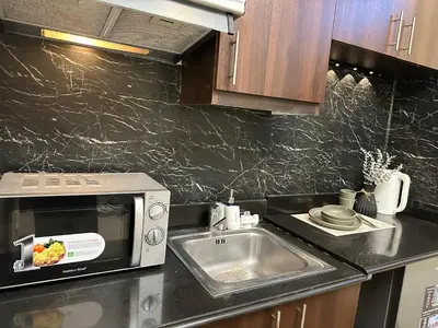 a kitchen with a sink and a microwave at Stamford Studio Condo in McKinley Hill, BGC Taguig in Manila