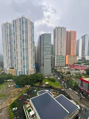 a city with tall buildings and a parking lot with cars at City Comfort Studio at Sunshine 100 in Manila
