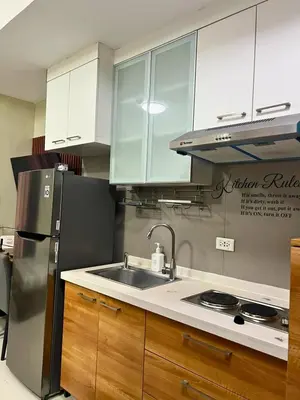 a kitchen with a stainless steel refrigerator and a sink at City Comfort Studio at Sunshine 100 in Manila