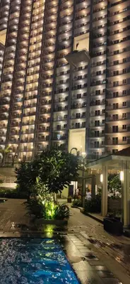 a large building with a tree in front of it at The Luxe at The Pent in Manila