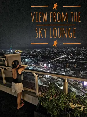a woman standing on top of the sky lounge at night at The Luxe at The Pent in Manila