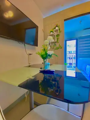 a glass desk with a vase of flowers on it at Shore 2 residences tower 1 in Manila