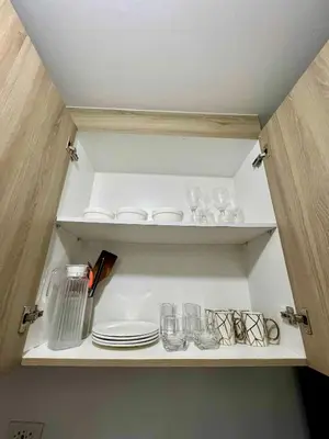 a cupboard with plates and glasses on it at Shore 2 residences tower 1 in Manila