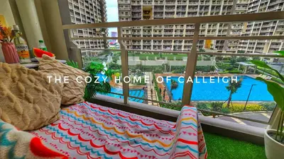 a couch sitting in front of a window with a view at The Cozy Home of Calleigh in Allegra in Manila