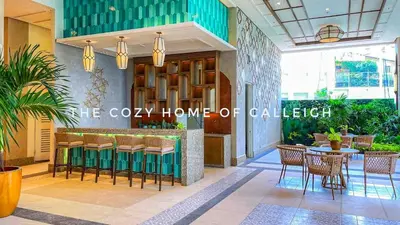 a lobby with a bar with chairs and a table at The Cozy Home of Calleigh in Allegra in Manila