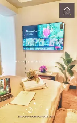 a room with a laptop and a tv on a wall at The Cozy Home of Calleigh in Allegra in Manila
