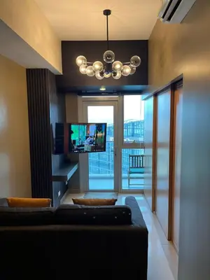 a living room with a couch and a flat screen tv at 1 Bedroom Luxe in BGC with Balcony & Free Parking in Manila