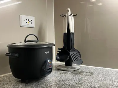 a kitchen counter with a whisk and a pot and spatula at 1 Bedroom Luxe in BGC with Balcony & Free Parking in Manila