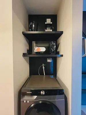 a kitchen with a washing machine and a microwave at 1 Bedroom Luxe in BGC with Balcony & Free Parking in Manila