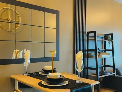 a table with two glasses and plates on it at 1 Bedroom Luxe in BGC with Balcony & Free Parking in Manila