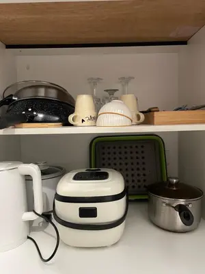 a kitchen with a toaster and other appliances on a shelf at Kasara Staycation Pasig in Manila