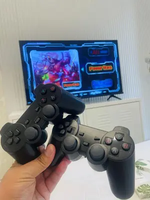 a person holding two video game controllers in front of a tv at Kasara Staycation Pasig in Manila