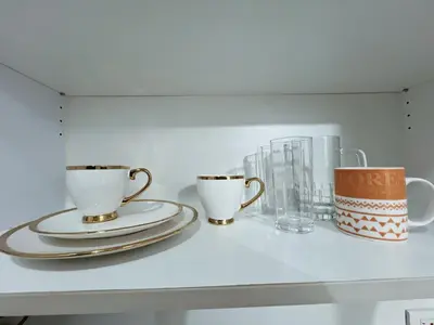 two coffee cups and glasses on a shelf at Pleasant Air Residences With Balcony and Fast Wi-Fi in Manila