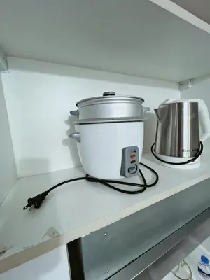 a slow cooker sitting on top of a kitchen counter at Pleasant Air Residences With Balcony and Fast Wi-Fi in Manila