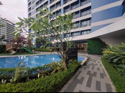 a swimming pool in front of a building at Pleasant Air Residences With Balcony and Fast Wi-Fi in Manila