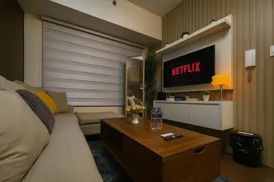 a living room with a couch and a tv at 2BR Air Residence, Makati City in Manila