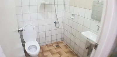 a white bathroom with a toilet and a sink at Nemar Building GF room w AC in Manila