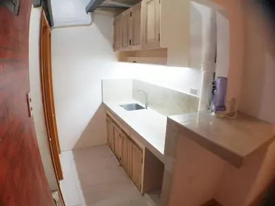 a small kitchen with a sink and a counter at Nemar Building GF room w AC in Manila