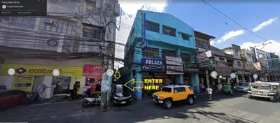 a street with buildings and a yellow jeep parked on the street at Nemar Building GF room w AC in Manila
