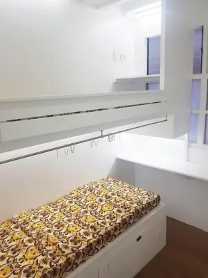 a white room with a bed with yellow and white at Nemar Building GF room w AC in Manila