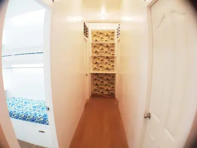 a hallway with a closet with wine bottles at Nemar Building GF room w AC in Manila