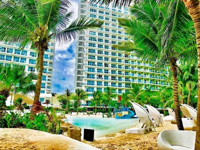 a view of a resort with a pool and palm trees at Azure Urban Resort Residences Parañaque City near NAIA Airport in Manila