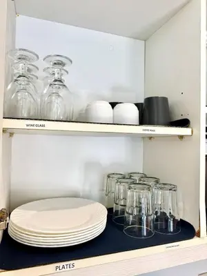 a shelf with plates and glass jars on it at Azure Urban Resort Residences Parañaque City near NAIA Airport in Manila