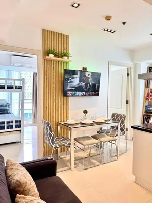 a living room with a table and chairs at Azure Urban Resort Residences Parañaque City near NAIA Airport in Manila
