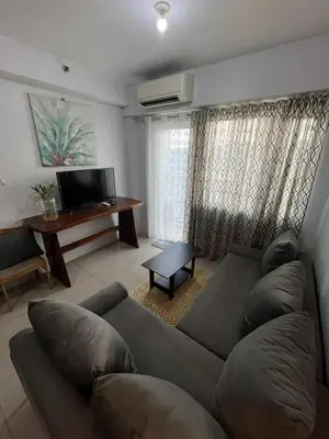 a living room with a couch and a table at 2 Bedroom Shore Residence Mall Of Asia Complex in Manila