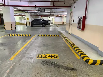 a parking garage with a car parked in it at Panoramic Views 2BR Family Stay in Mckinley BGC in Manila