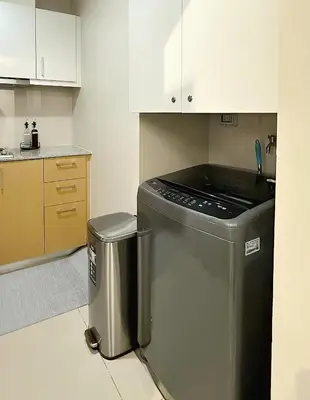 a kitchen with a dishwasher and a trash can at Luxe and Modern 1BR Unit in BGC in Manila