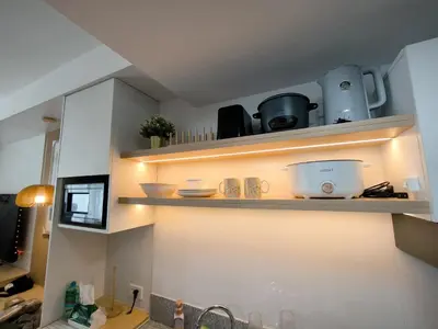 a kitchen with white walls and shelves with bowls and appliances at Prime Zen in Silang
