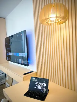 a laptop computer sitting on a table in front of a tv at Prime Zen in Silang
