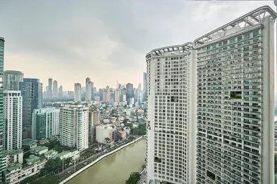 a view of a city with a river and buildings at Cozy Crib at Acqua Residences - Rockwell Views in Manila