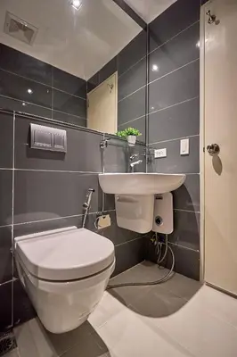 a bathroom with a toilet and a sink at Cozy Crib at Acqua Residences - Rockwell Views in Manila
