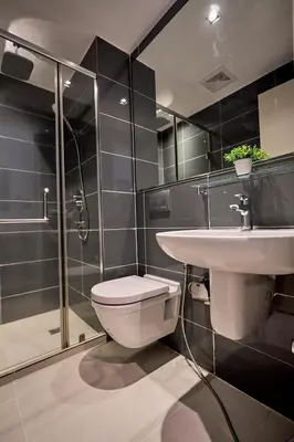 a bathroom with a toilet and a sink and a shower at Cozy Crib at Acqua Residences - Rockwell Views in Manila