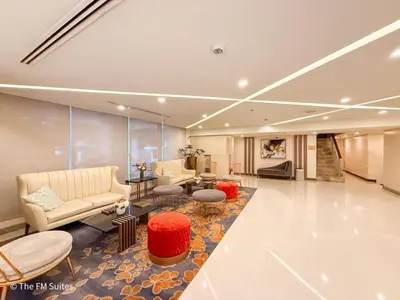 a lobby with couches and chairs and a table at Cozy and Spacious Fast WiFi FREE Access Pool and Gym in Manila