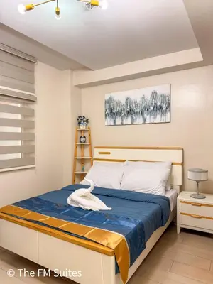 a bedroom with a bed with a blue comforter at Cozy and Spacious Fast WiFi FREE Access Pool and Gym in Manila