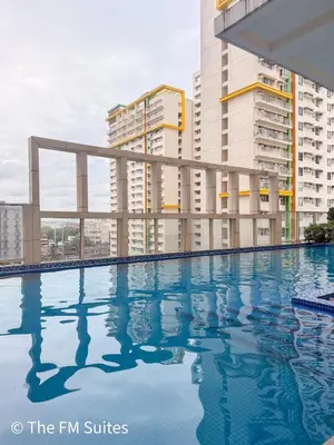 a swimming pool in front of some tall buildings at Cozy and Spacious Fast WiFi FREE Access Pool and Gym in Manila