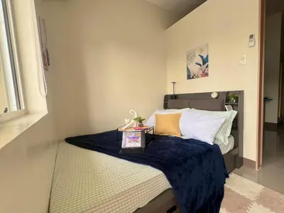 a small bedroom with a bed with a blue blanket at 1 Bedroom Condo Unit Near SM City Sucat and NAIA Terminal in Manila