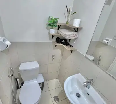 a white bathroom with a toilet and a sink at 1 Bedroom Condo Unit Near SM City Sucat and NAIA Terminal in Manila